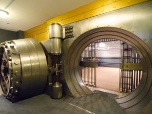 A photograph of a very large bank vault with the vault door wide open.