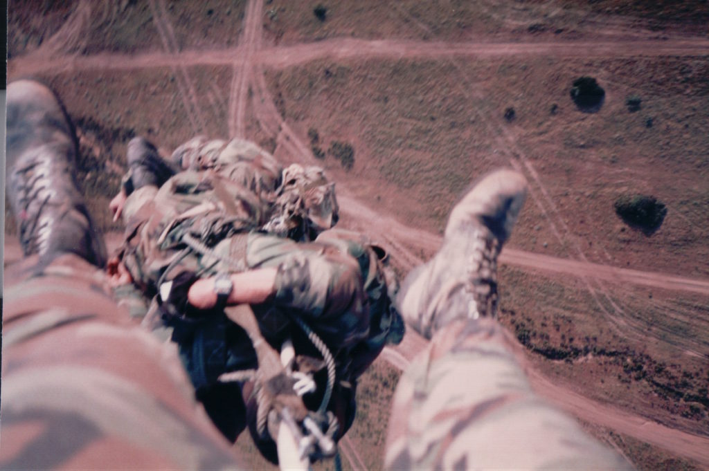 Selfie of Marine's Feet hanging on rope under a helicopter at 1,000 feet.