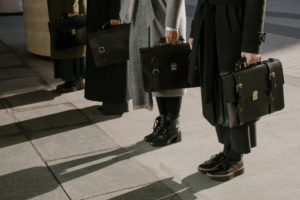 four men standing with briefcases.