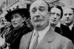 A man crying during WWII as Nazi troops claimed Paris.