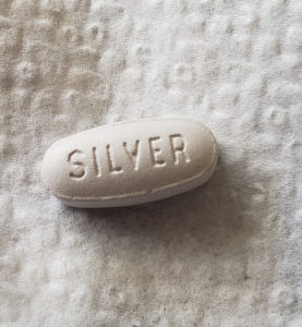 A close-up photo of a pill that is stamped 'Silver'.